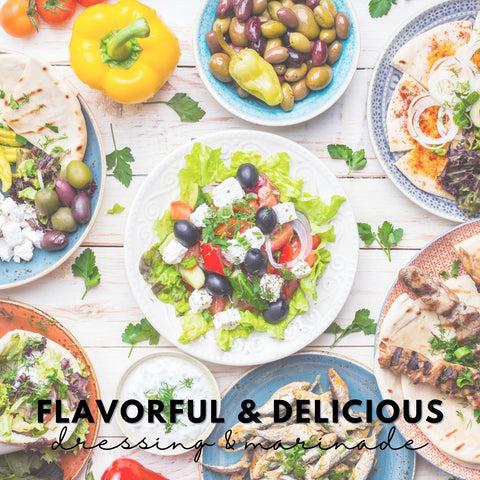 White barn table with seven greek dishes on it including olives, greek salad, pitas, chicken skewers.